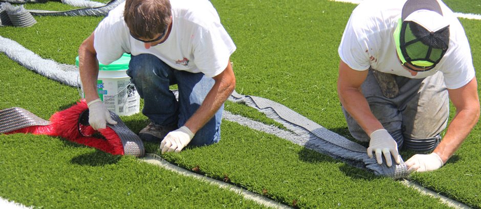 two crew replacing turf field markings